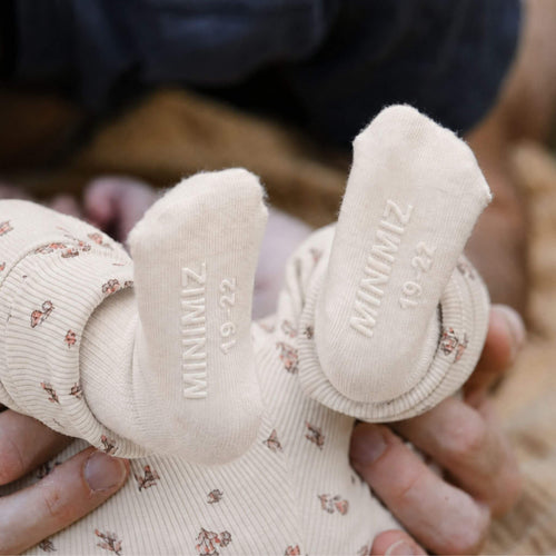 bébé avec chaussettes antidérapantes écru