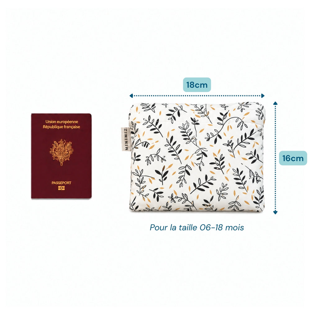 Gigoteuse Rosemary pliée dans son pochon de 18 x 16 cm à côté d'un passeport, idéale en avion