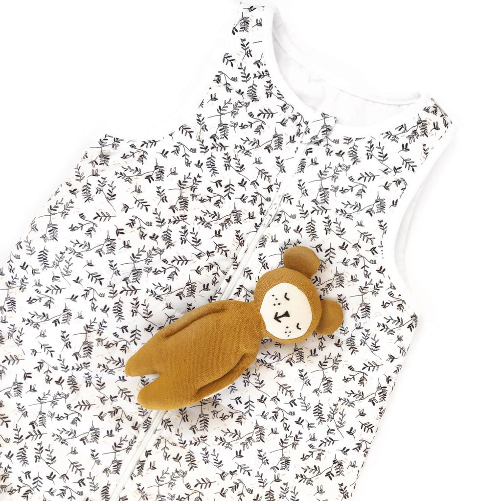 Détail de la gigoteuse de voyage Rosemary, motif feuillage, avec un doudou ours